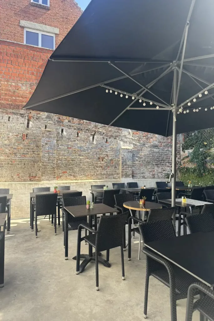 Terras van Da Leonardo met tafels onder een grote parasol
